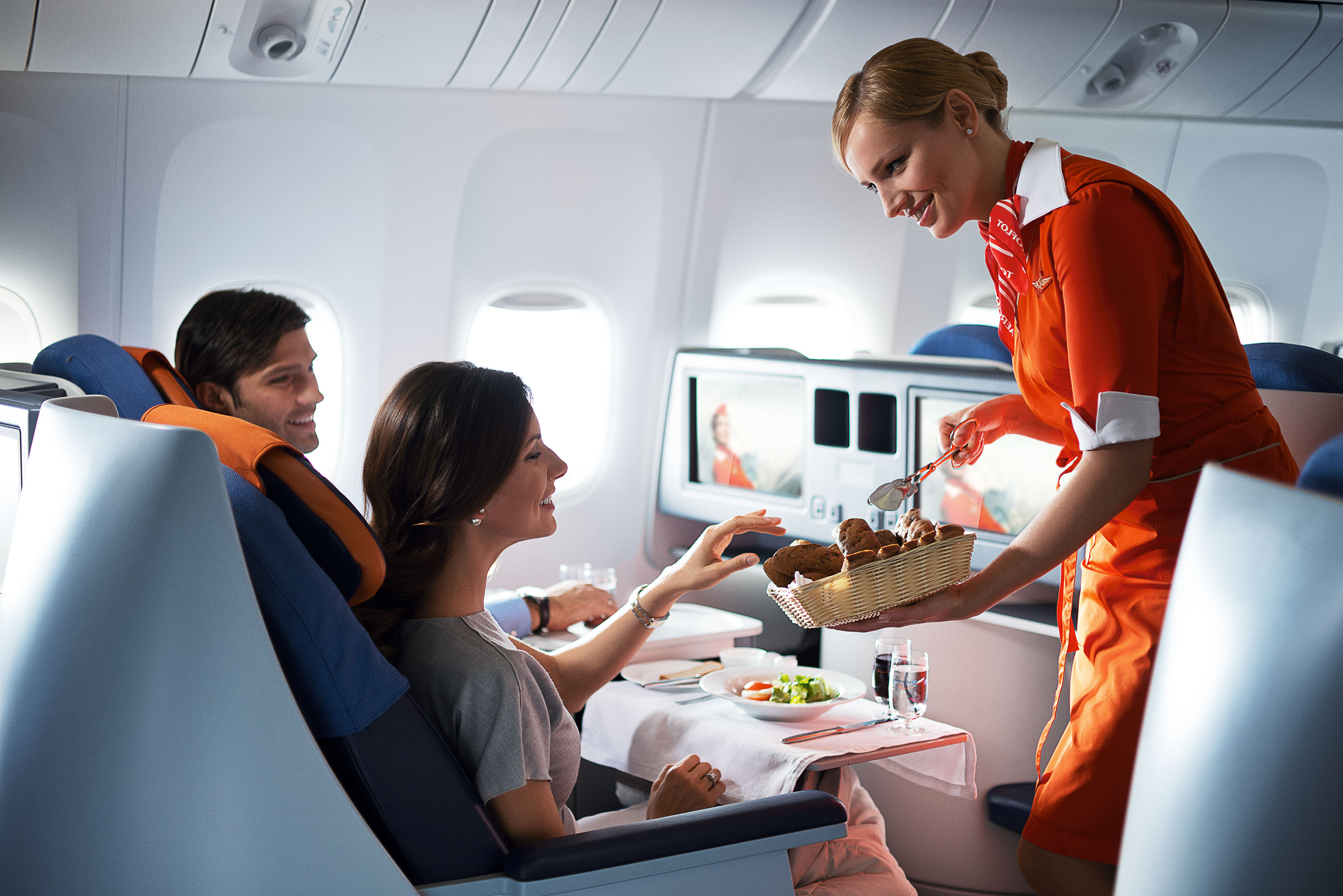 Организация обслуживания туристов. Еда в самолете. Борт самолета. Пассажиры на борту самолета. Стюардесса с едой.